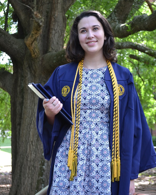 woman in graduation gown holding diploma